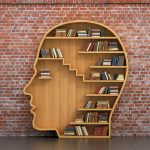 Concept of training. Wooden bookshelf full of books in form of man head on a bricks background. Science about human. Psychology. A human have more knowledge.
